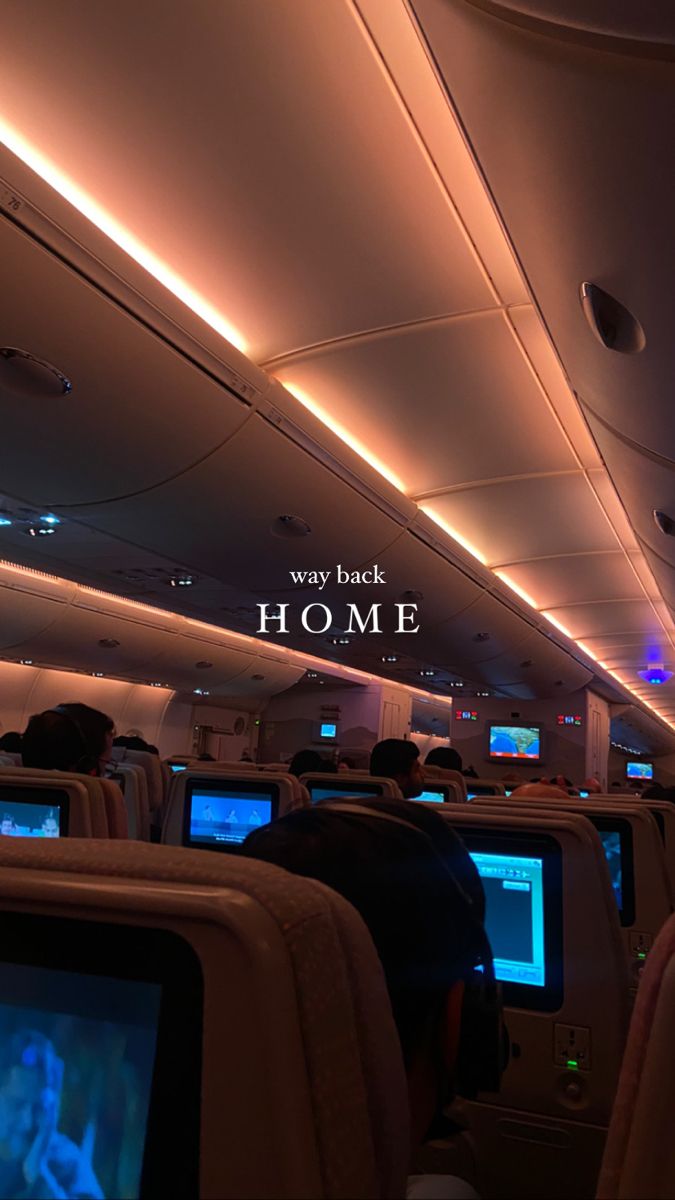 the inside of an airplane with people sitting in seats watching televisions and laptops