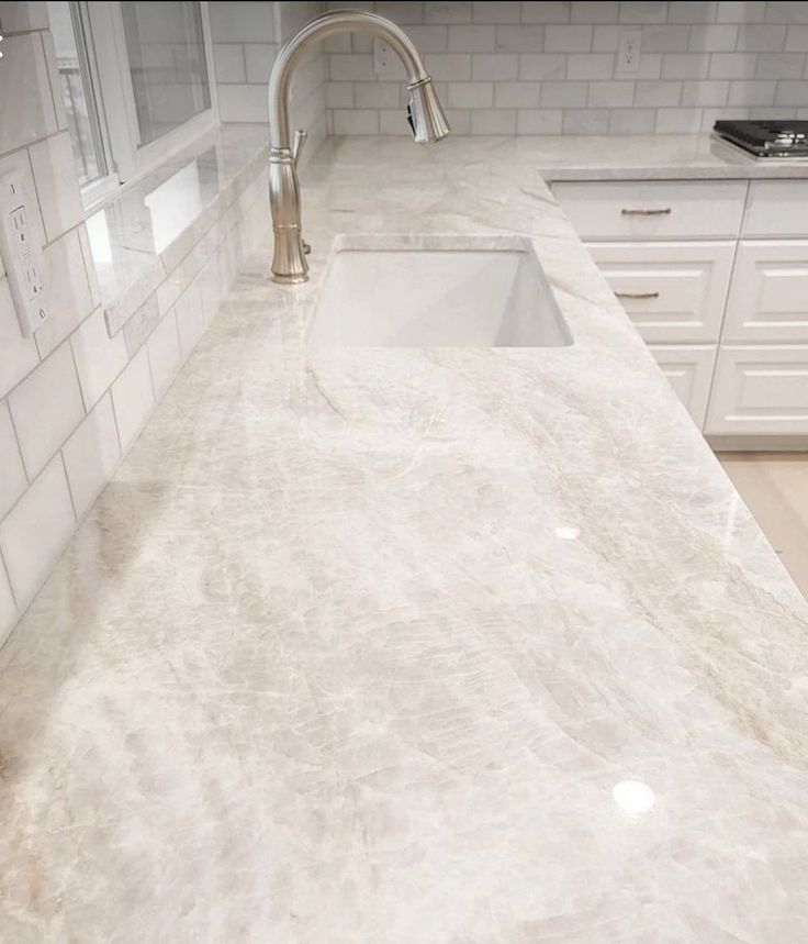 a kitchen counter top with a sink and faucet in the middle of it