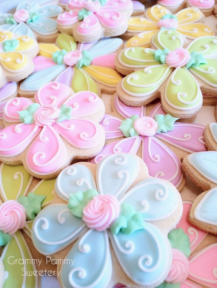 decorated cookies are arranged in the shape of flowers and butterfly's on top of each other