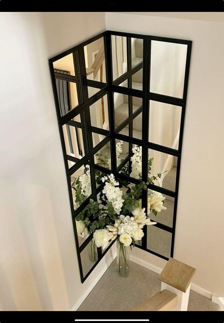 a vase filled with white flowers sitting next to a mirror