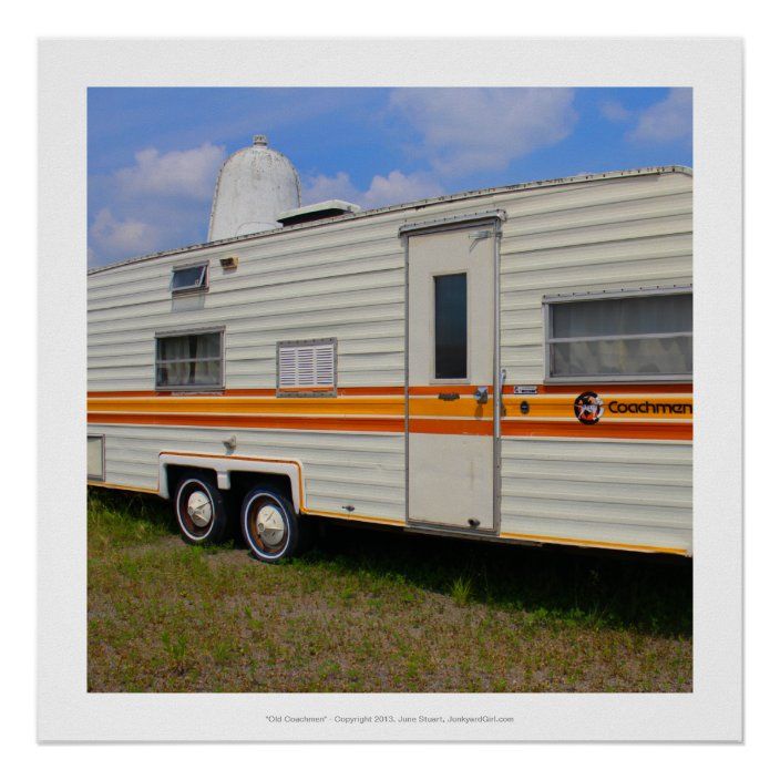 an old camper trailer parked in the grass