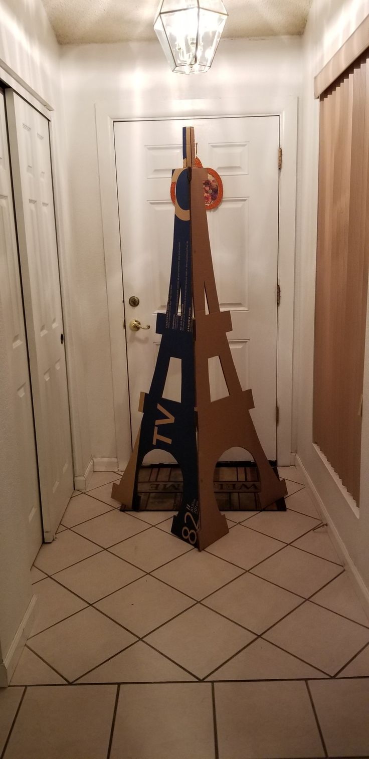 the eiffel tower is made out of cardboard and sits in an empty hallway