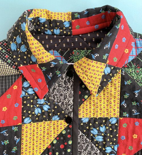 a close up of a shirt with different patterns on it and the collar is black, yellow, red, and blue