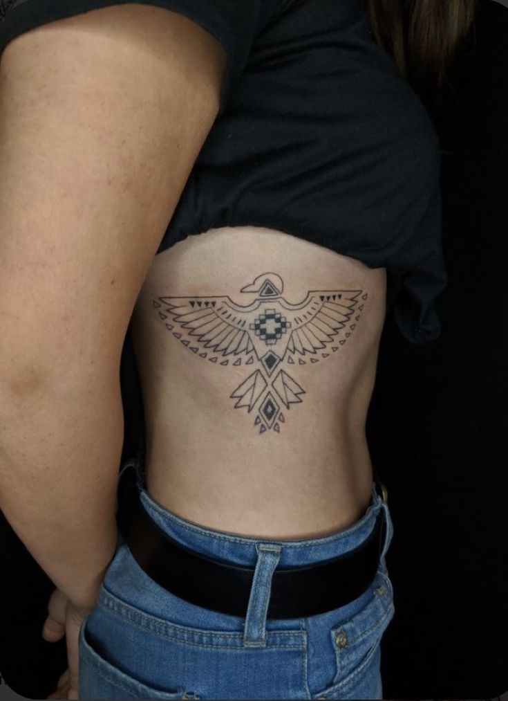 a woman's stomach with a tattoo on her belly and an eagle in the center