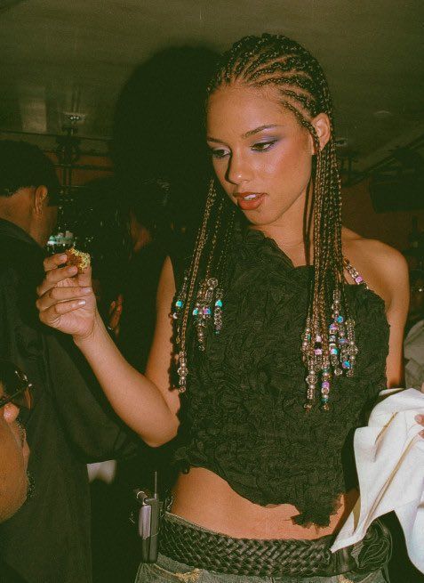 a woman with braids holding a drink in her hand