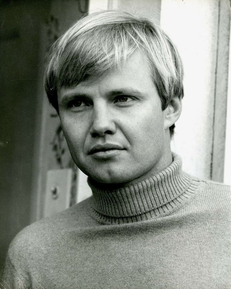 black and white photograph of a man with blonde hair wearing a turtle - neck sweater