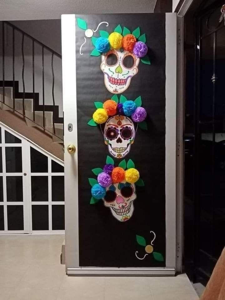 the door is decorated with colorful paper flowers and skulls on it's sides, as well as an entry way