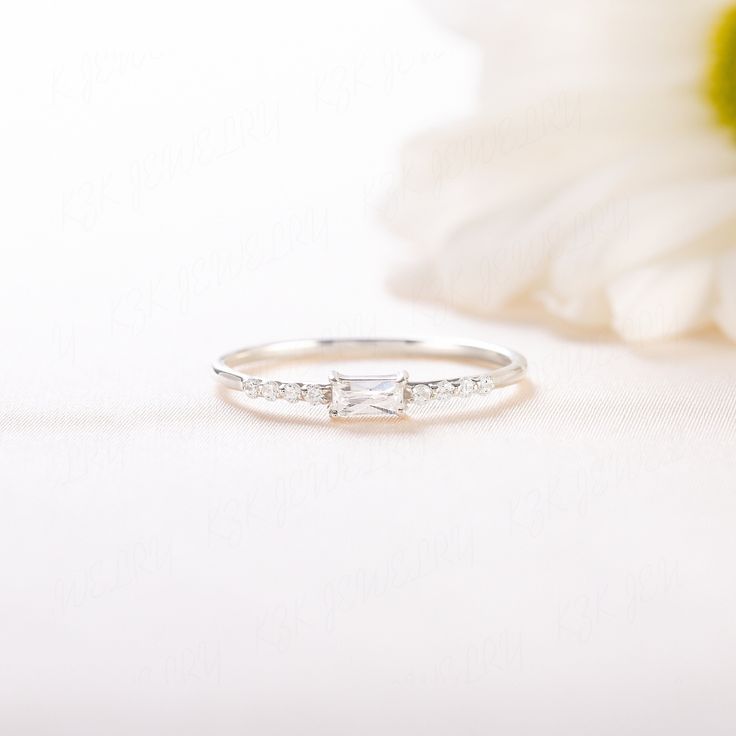 a diamond ring sitting on top of a white flower