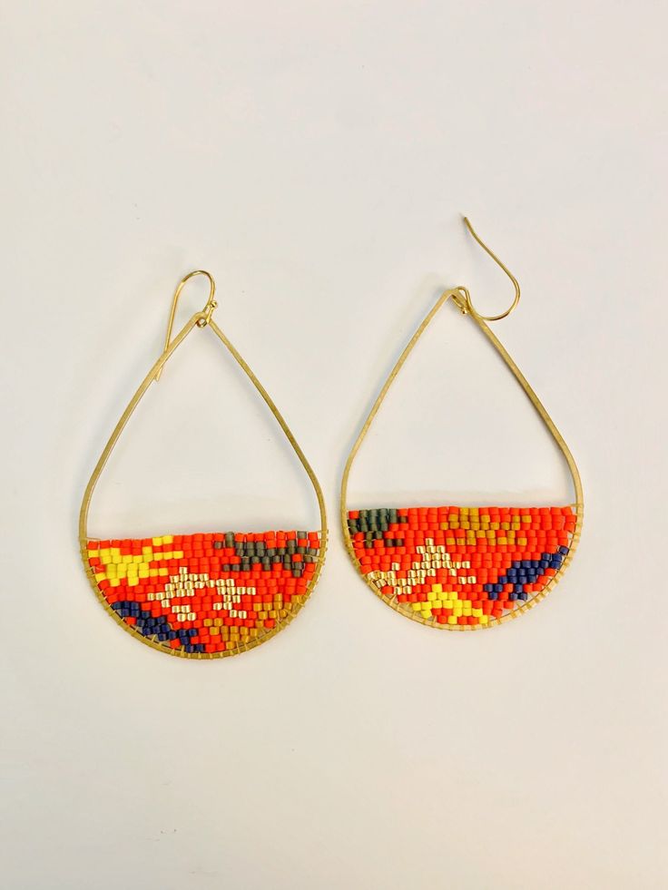 "Lovely and lightweight, these bead woven brass teardrops feature an \"ikat\" inspired design in bright vermillion red, blue grey, mustard,gold and yellow. These non matching earrings are made to order and there may be some slight variation in each pair making them one of a kind. Earrings are made with Miyuki Delica Glass beads on brass hoops with gold plated earrings wires with plastic stoppers so you won't lose your earrings when wearring them. Each pair is handmade by me in my studio in Ottaw Multicolor Teardrop Beaded Earrings For Festival, Gold Teardrop Earrings With Colorful Beads, Multicolor Handwoven Teardrop Earrings, Red Teardrop Beaded Earrings For Festival, Artisan Colorful Beaded Teardrop Earrings, Orange Teardrop Beaded Earrings With Ear Wire, Adjustable Multicolor Beaded Teardrop Earrings, Orange Teardrop Beaded Earrings With Dangling Beads, Handwoven Multicolor Teardrop Earrings