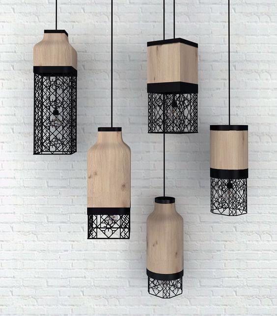 four wooden vases hanging on a white brick wall with black metal cage around them