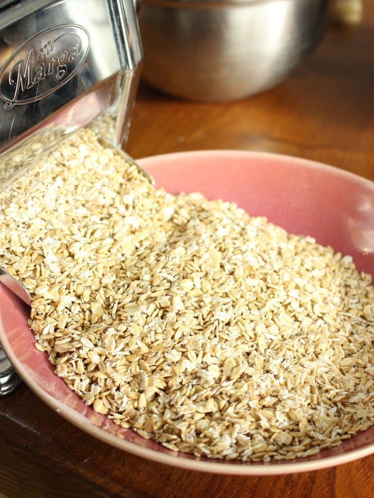 a pink bowl filled with oats on top of a wooden table