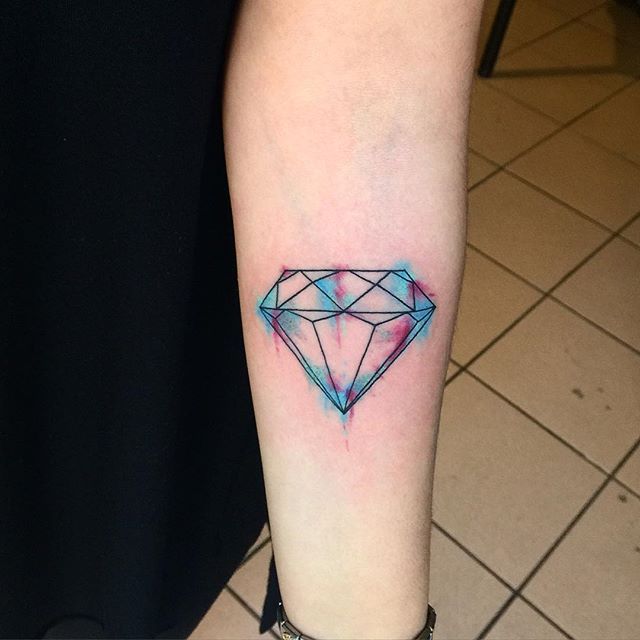 a small diamond tattoo on the arm