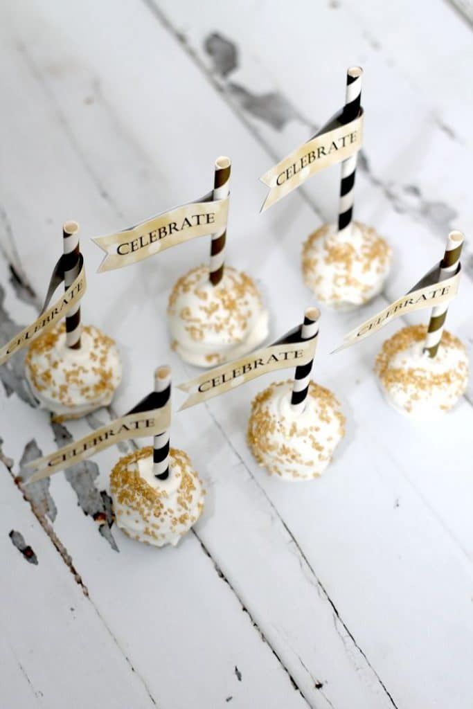 there are many desserts on the table with name tags attached to each cake ball