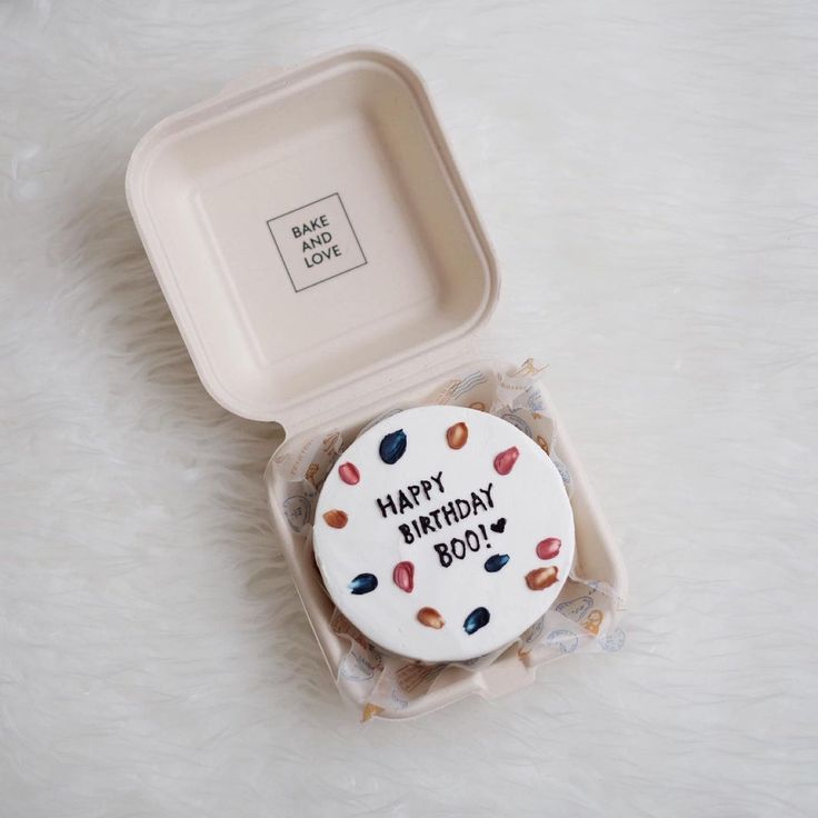 a birthday cake in a plastic container on a white surface with the words happy birthday boy written on it