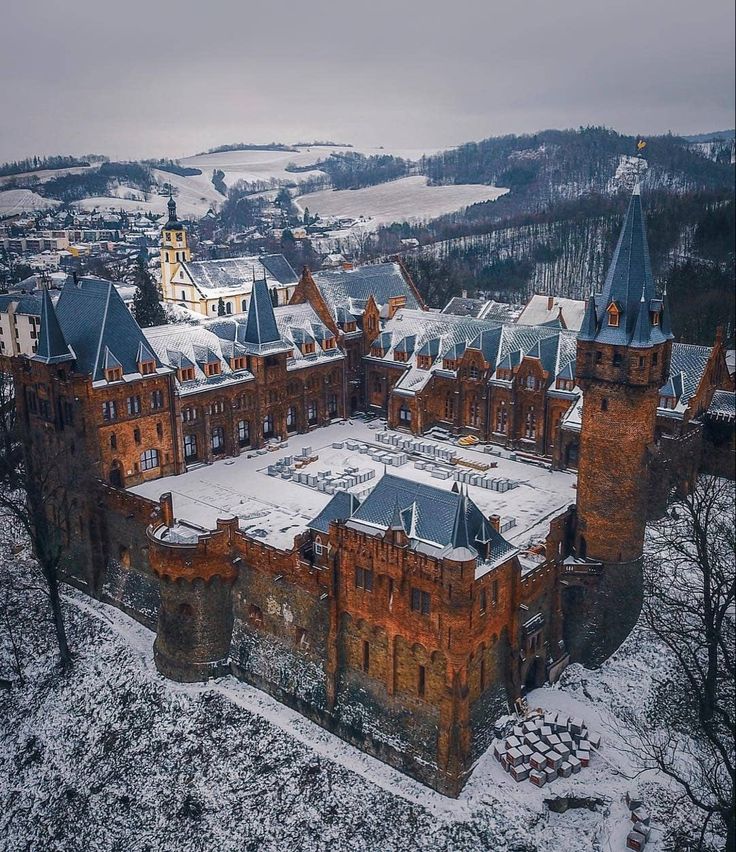 an aerial view of a castle in the middle of winter with snow on the ground