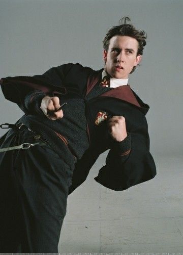 a man in a harry potter costume pointing at the camera with his right arm out