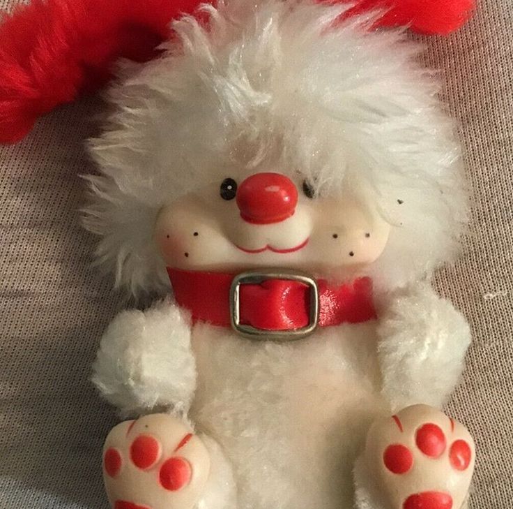 a white stuffed animal with red nose and legs