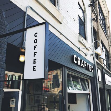 the outside of a coffee shop with signs on the front and side of the building