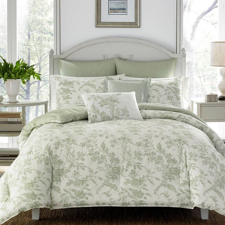 a bed with green and white comforters in a bedroom