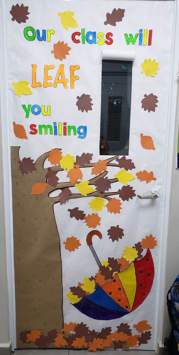 a classroom door decorated with fall leaves and an umbrella that says our class will leaf you smiling