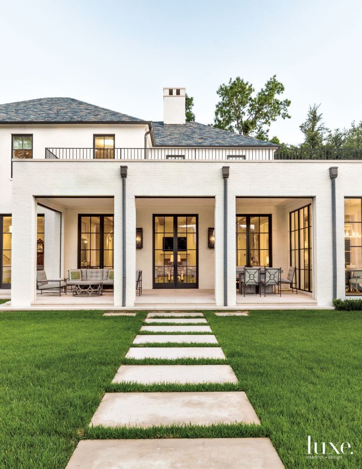 a large white house sitting on top of a lush green field