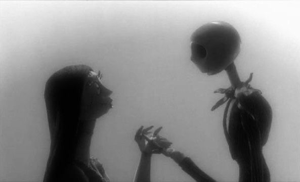 two women in black and white holding an alien head