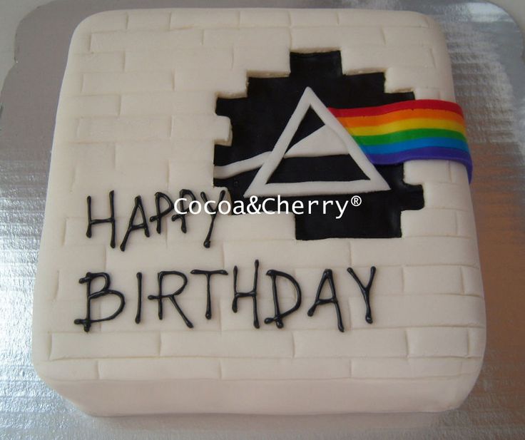 a birthday cake with the words happy birthday written on it and a rainbow in the background