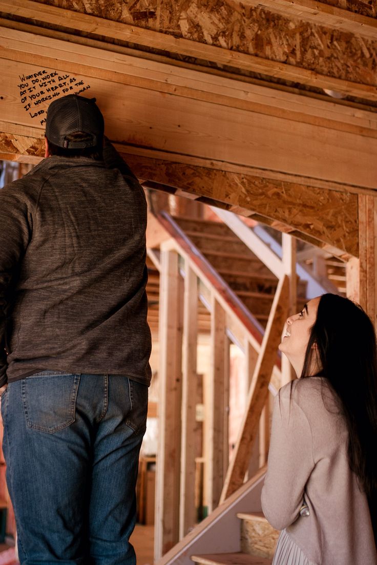 a man standing next to a woman in a room under construction