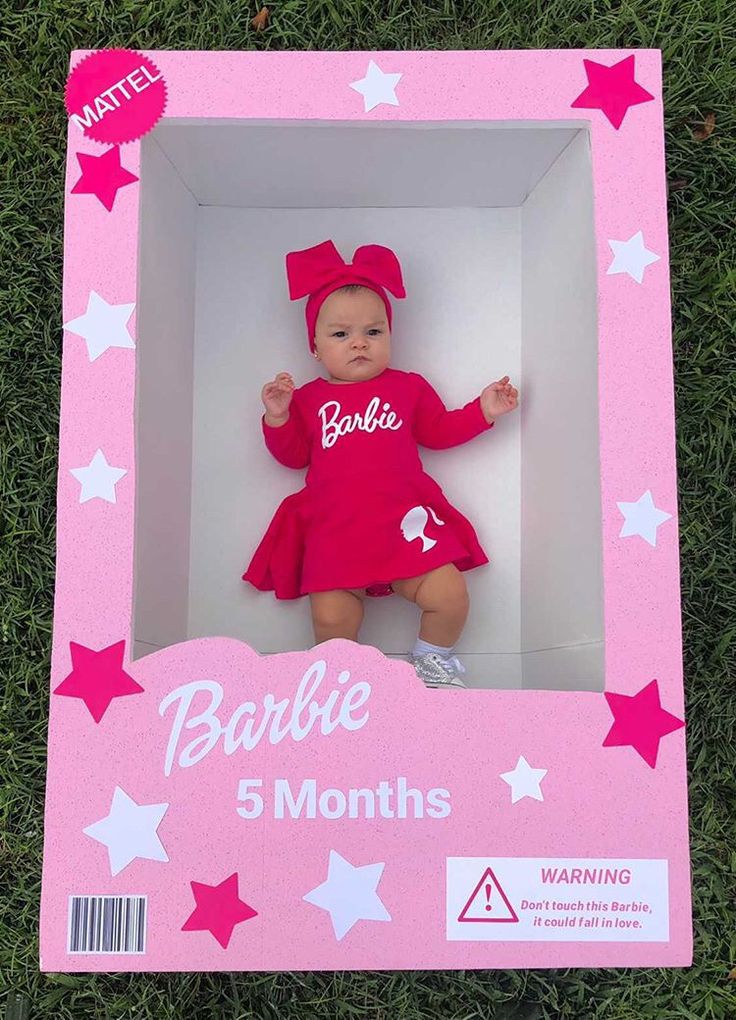 a baby doll in a pink box with stars on the side and name barbie 5 months