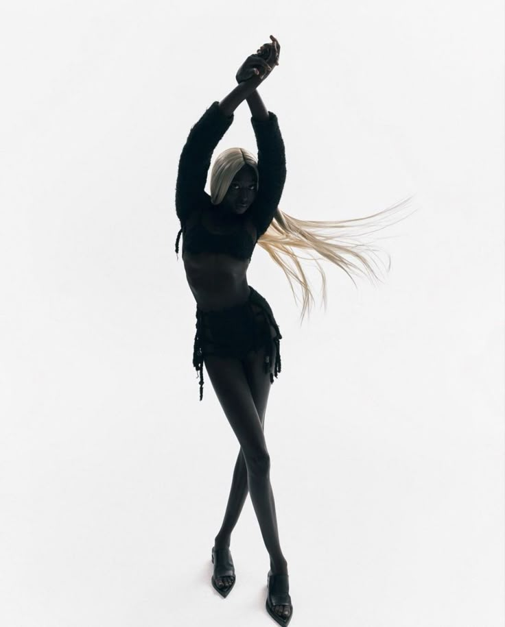 a woman in black is dancing with her hair blowing back and holding a cell phone up to her ear