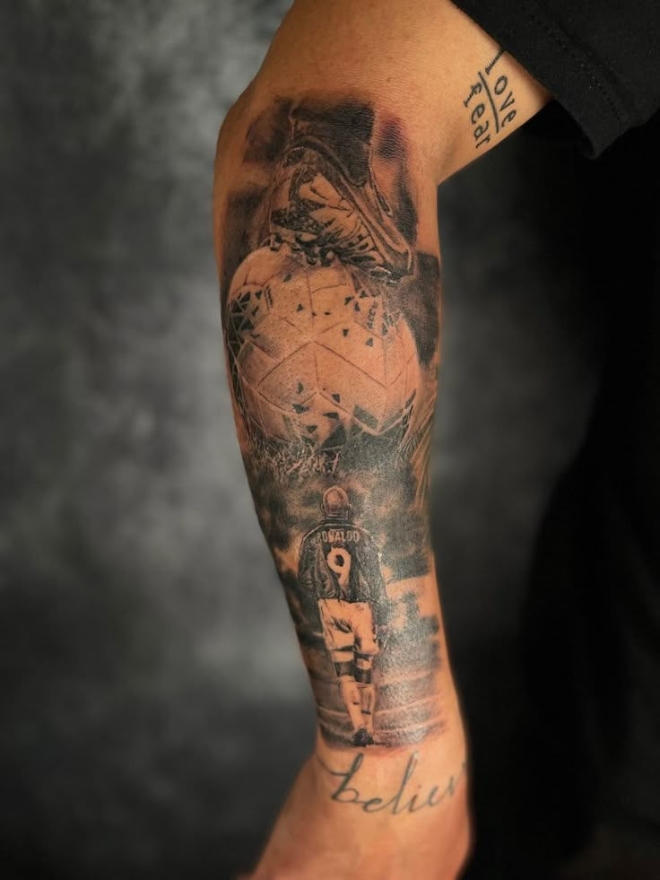 a man with a tattoo on his arm is holding a soccer ball in his hand