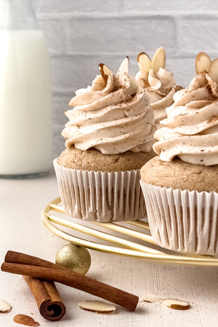 two cupcakes with frosting and nuts on a plate