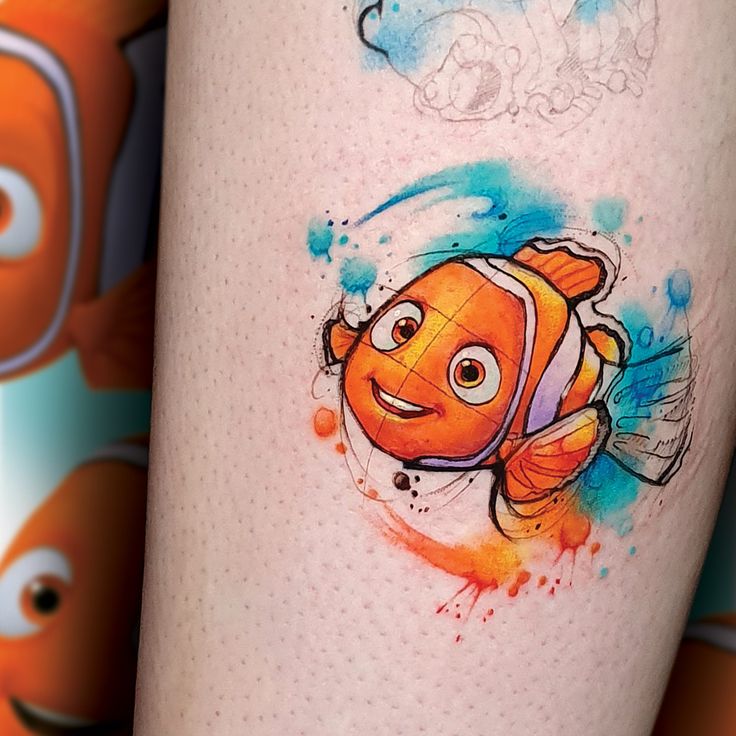 an orange and white clown fish tattoo on the right side of the leg, with blue watercolor splashes around it