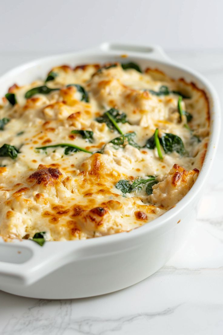 a casserole dish with cheese and spinach