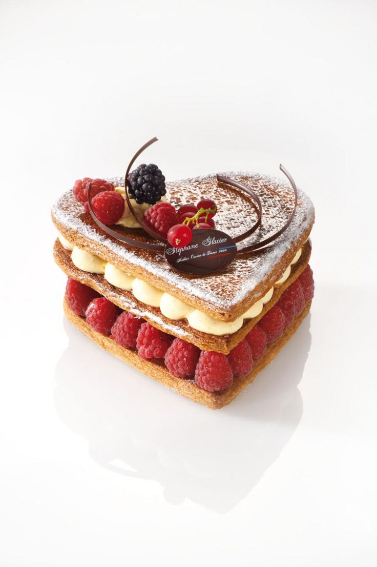 a cake with raspberries and chocolate on top is sitting on a white surface