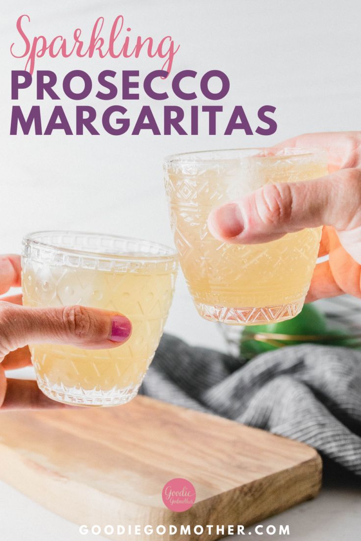 two people are toasting and holding glasses with lemonade in front of them on a cutting board