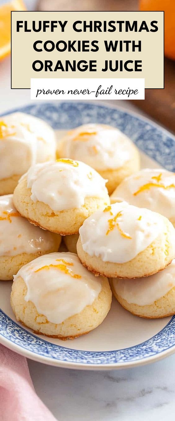 a white plate topped with orange cookies covered in frosting next to an orange slice