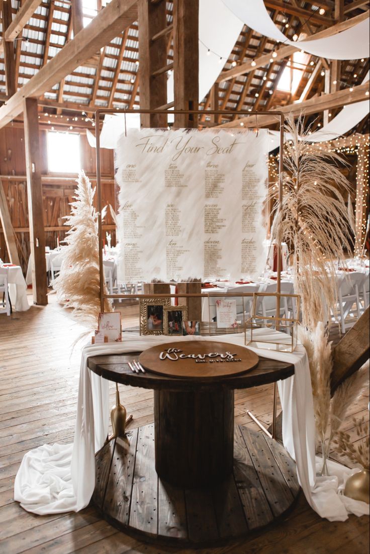 a wooden table topped with a cake next to a tall white banner on top of a wooden floor