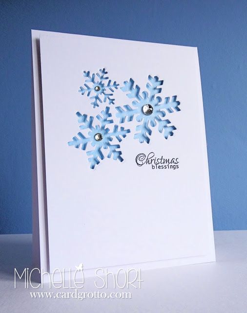 a white card with blue snowflakes on it and the words merry christmas written in silver