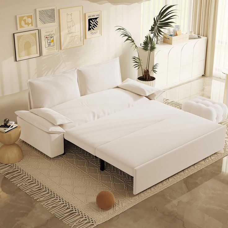 a large white bed sitting on top of a rug in a living room next to a window