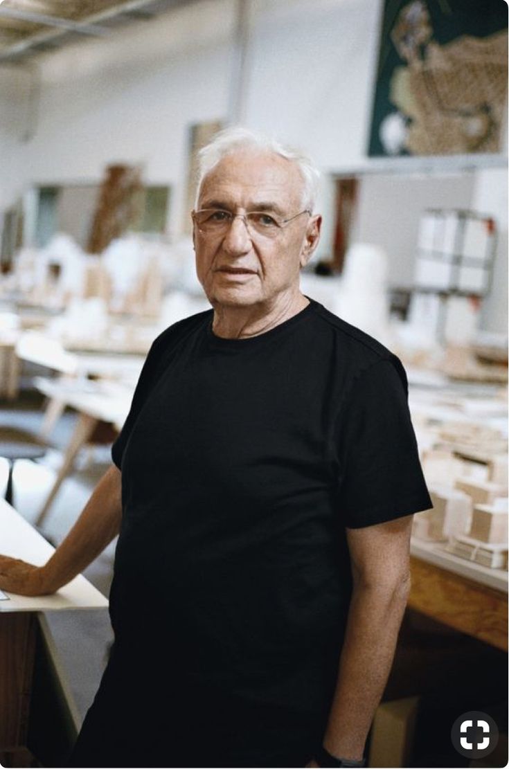 an older man standing in a room with lots of tables and chairs on the floor