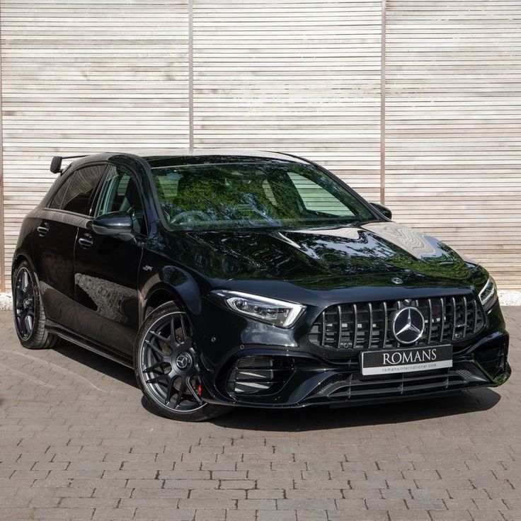 a black mercedes cla parked in front of a building