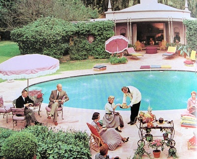 an outdoor pool with people sitting around it