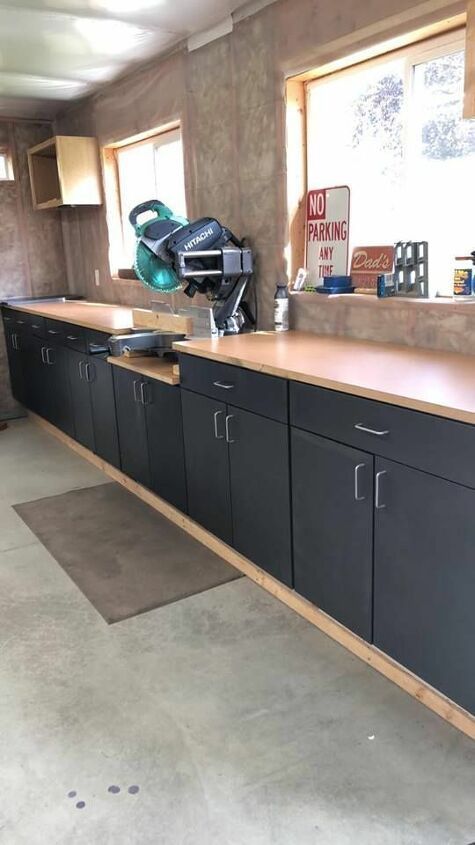 an unfinished kitchen with black cabinets and wood counter tops