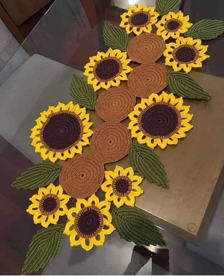 crocheted sunflowers are arranged on a table