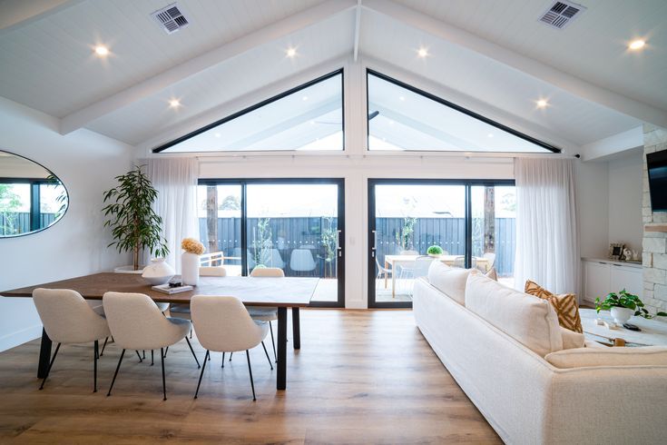 a living room filled with furniture and a flat screen tv mounted to the side of a wall