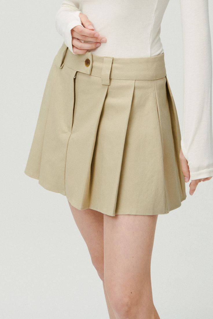 Front button and zip fly closure Kick pleats skort Short length 98% Cotton 2% Span Professional Clean Only / Do Not Tumble Dry XS/S: Waist: 35cm (13.8in) / Hip: 45cm (17.7in) / Hem: 56.5cm (22.2in) / Length: 35cm (13.8in) / Model's height is 7′ 5″ (170cm) Bust 32.5in Waist 23.5in Hip 34in and wearing XS/S Made in Korea 사이즈 정보Size information (단위:cm)(Unit : inch) SXS/S 사이즈 정보 Size information 허리Waist 3513.8 엉덩이Hip 4517.7 밑단Hem 56.522.2 총장Length 3513.8 MS/M 사이즈 정보 Size information - 위의 실측사이즈는 '단면의 길이'입니다. 참고해 주세요.- 사이즈는 측정방법에 따라 1~3cm 정도 오차가 있을 수 있습니다.- 제품색상은 사용자의 모니터의 해상도에 따라 실제 색상과 다소 차이가 있을 수 있습니다. - The above measurement size is'length of section'. please note.- Depending on the measurement method, there may be an error of 0.5~1inch.- The product color may differ slightly from the actual Short Cotton Pleated Skirt, Beige Pleated Short Bottoms, Beige Pleated Short Length Bottoms, Casual Pleated Shorts For Fall, Beige Pleated Shorts, Chic Pleated Beige Shorts, Workwear Skort With Button Closure And Short Length, Spring Casual Pleated Hem Shorts, Chic Beige Pleated Shorts