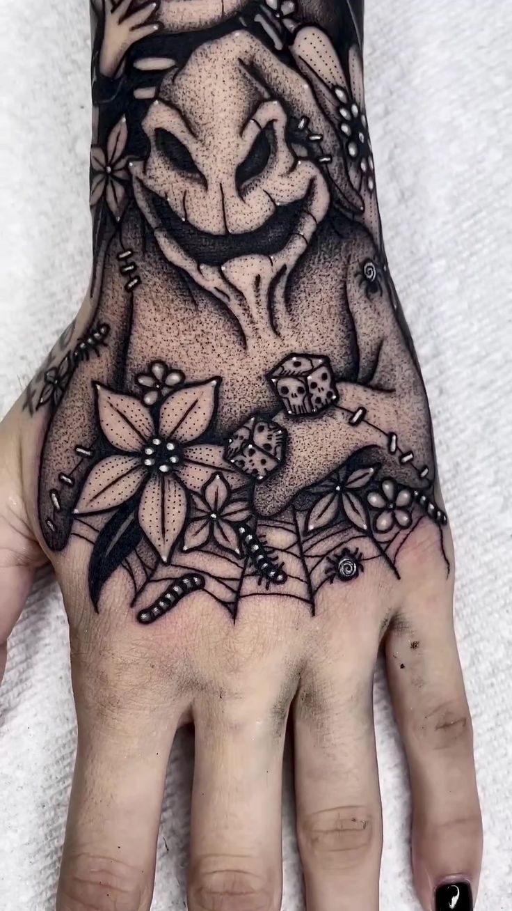 a person's hand with a tattoo on it and flowers around the wrist area