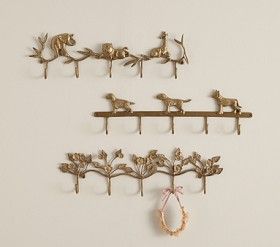 three metal hooks with birds and flowers on them, hanging from the side of a wall