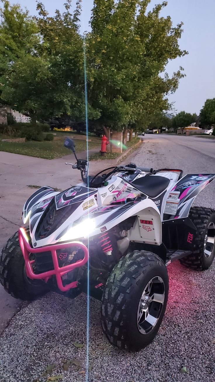 a white and pink four wheeled vehicle parked on the street